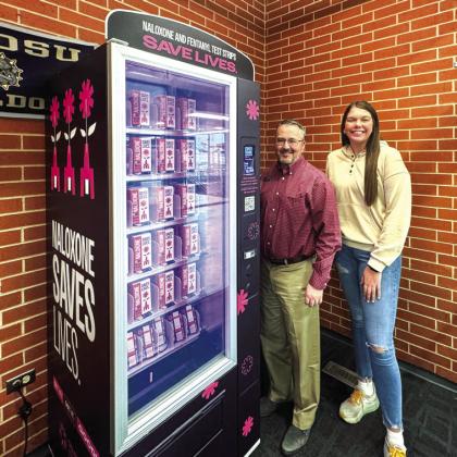 Dr. Adam Johnson, left, vice president for Student Services, and Jessica Finley, president of the Student Government Association, are shown with a NARCAN vending machine on the SWOSU campus.